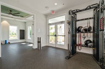 a home gym with weights and a door to a patio